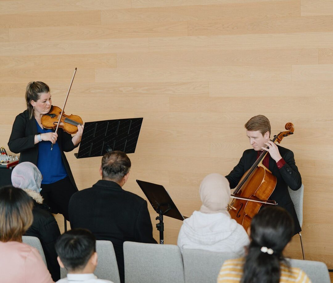 A woman playing a violin and a man playing a cello.