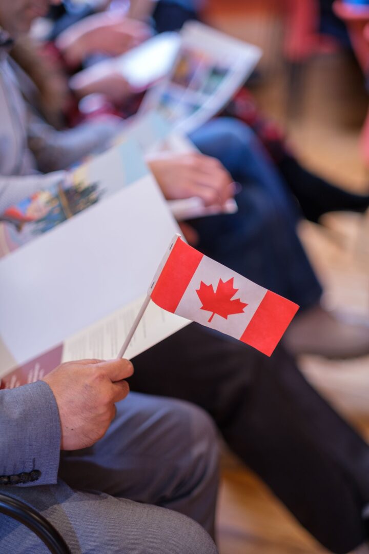 Person holding small Canadian flag.