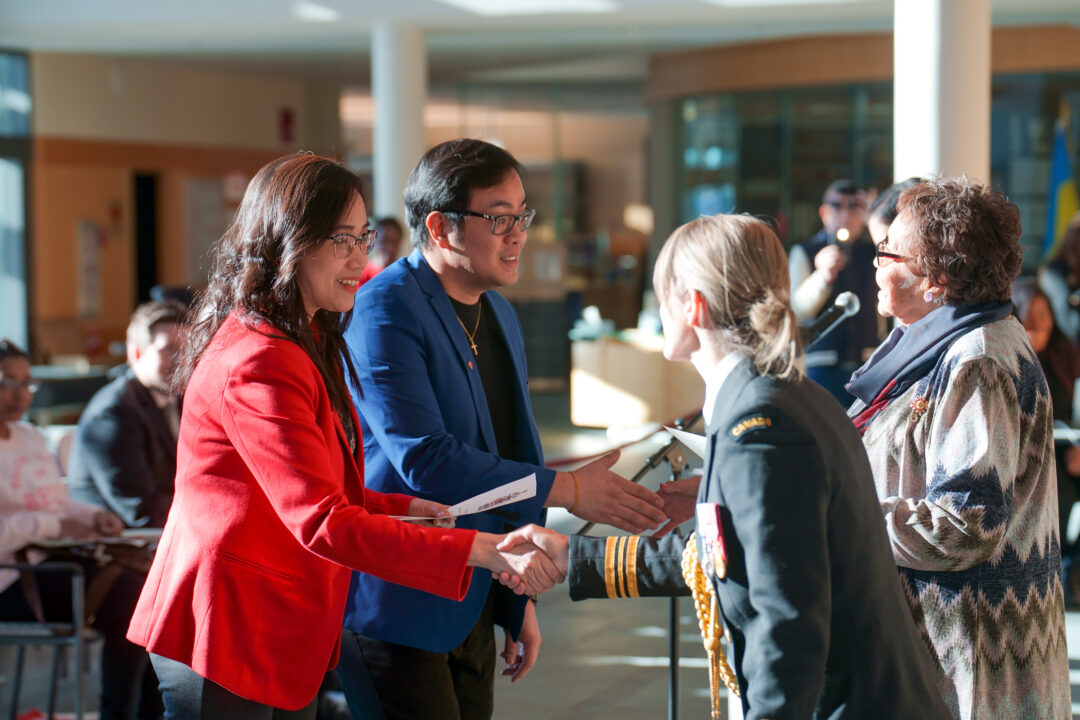 People shaking hands at Canadian citizenship ceremony.