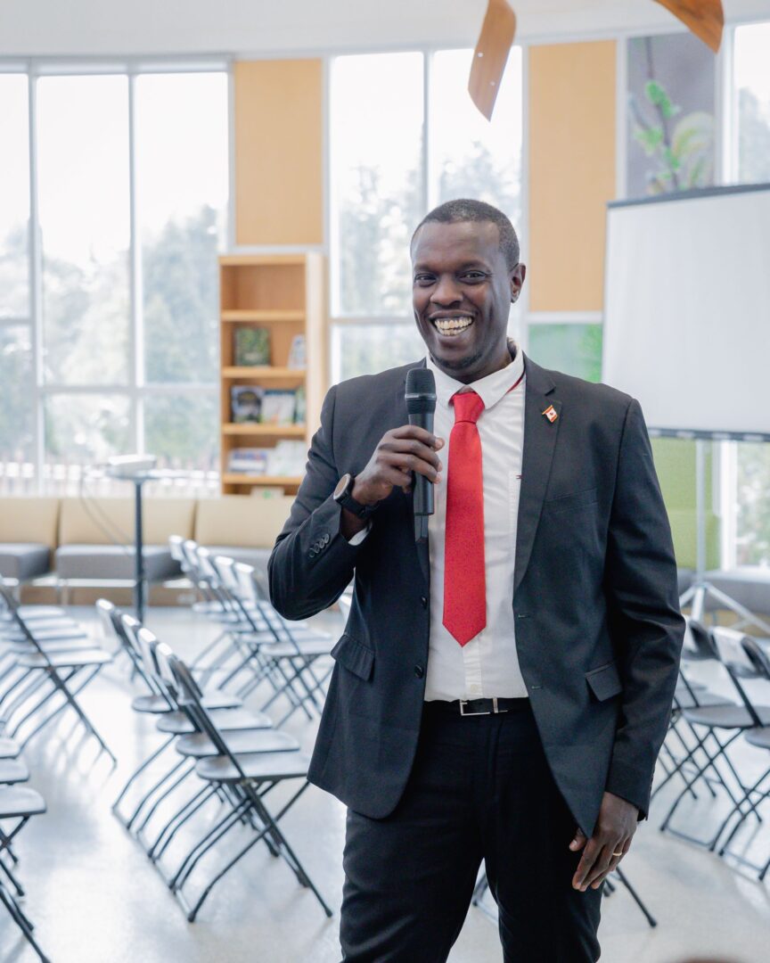 Man standing with microphone during ICC's roundtable discussion share backs.