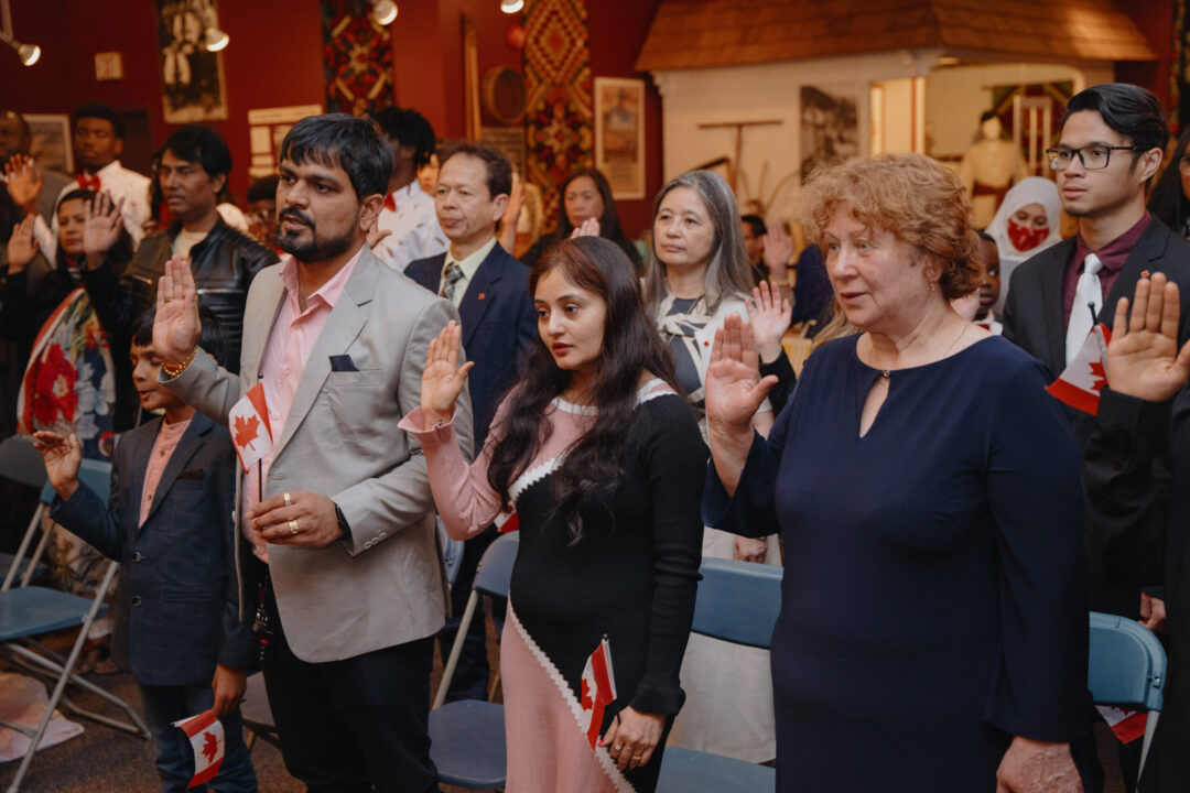 People taking the oath of citizenship at a Canadian citizenship ceremony.