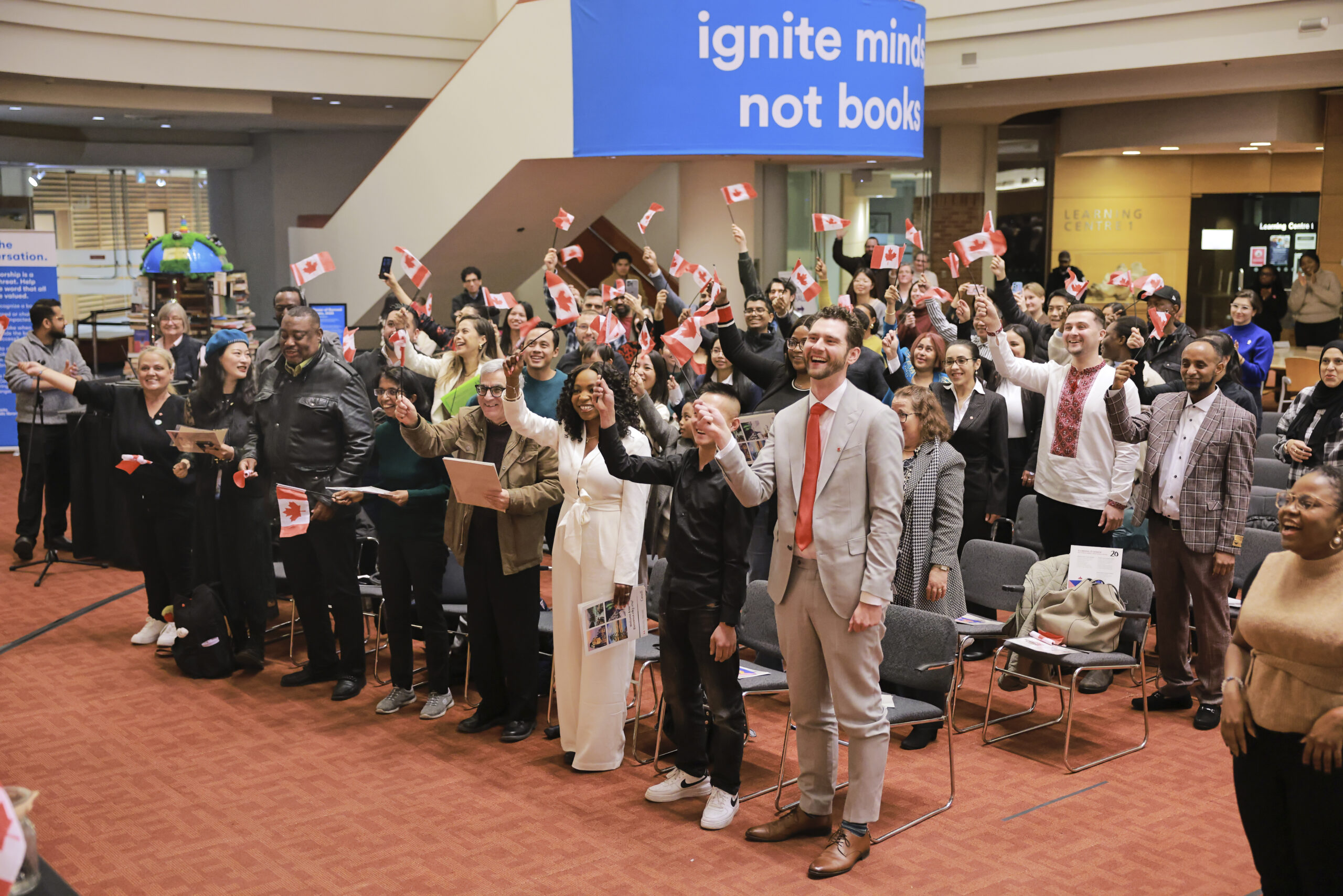 New citizens holding up and waving their Canadian flags